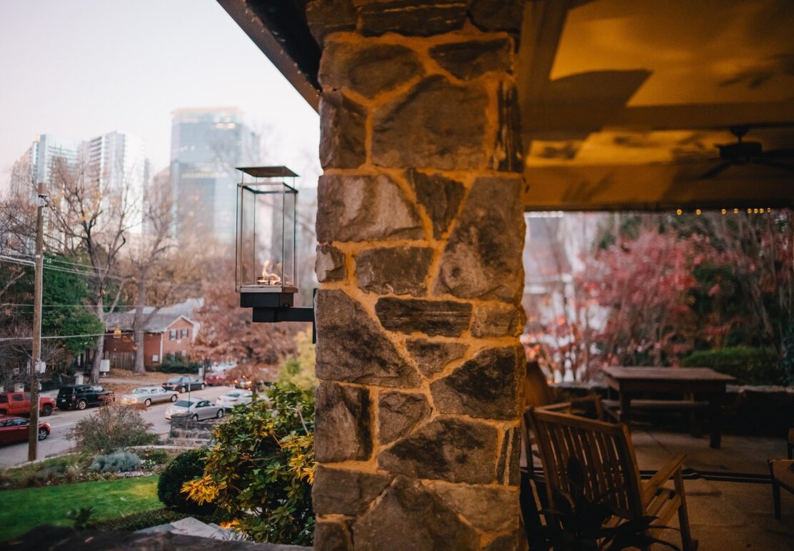 The front porch of Stonehurst Place with the city skyline in the background