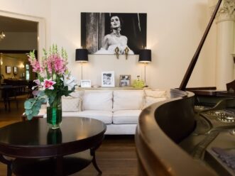 Artwork and a grand piano in the Music Room at Stonehurst Place