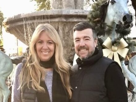 Kris and Jason Lahman stand in from of a sculptural fountain
