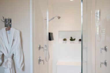 Master Suite glass walk-in shower with white robe hanging on wall in Stonehurst Place