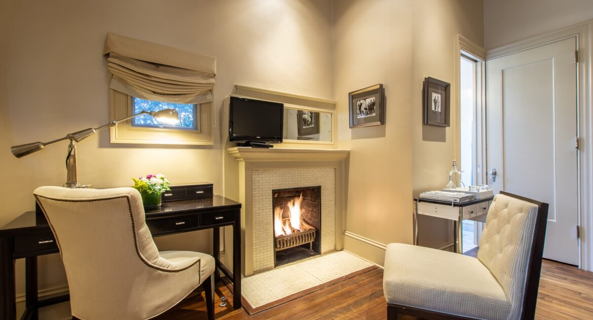 The Piedmont Suite sitting area with a fireplace and tv above in Stonehurst Place