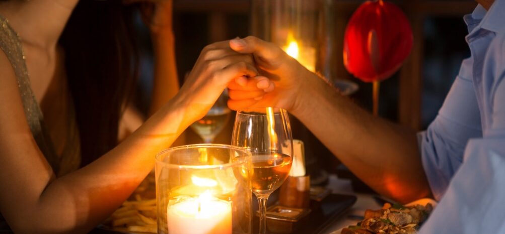 A man and woman holding hands during dinner at The Lawrence in Midtown Atlanta
